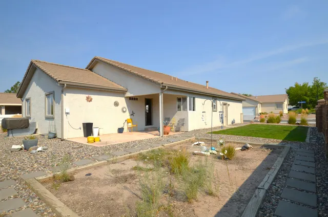 a view of a house with backyard and sitting area
