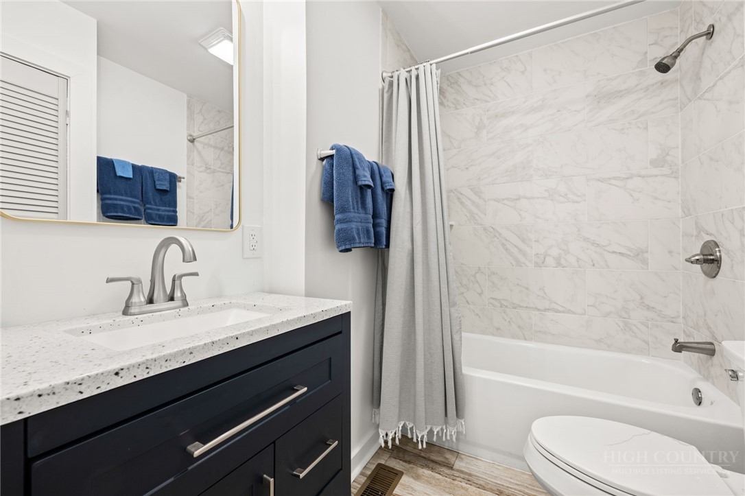 811 Pine Ridge Road Beech Mountain, NC 28604 - Photo 19 of 26 a bathroom with a granite countertop sink toilet and shower