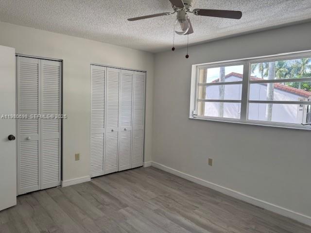13404 Southwest 62nd Street, Unit 101L Miami, FL 33183 - Photo 21 of 46 an empty room with wooden floor fan and windows