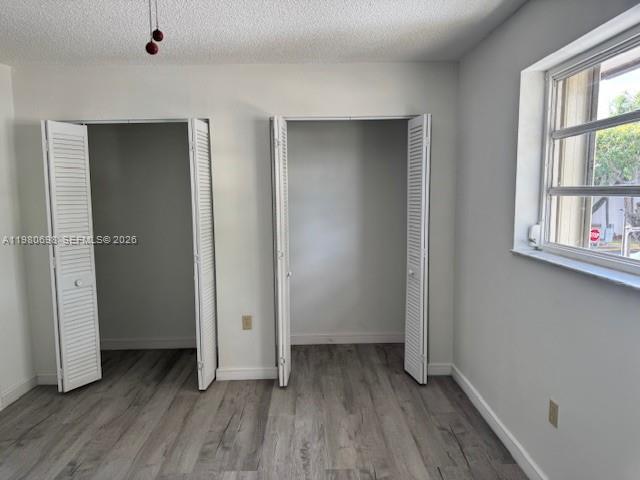 13404 Southwest 62nd Street, Unit 101L Miami, FL 33183 - Photo 24 of 46 an empty room with wooden floor and windows
