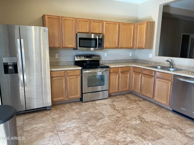 a kitchen with stainless steel appliances granite countertop a stove a sink and a refrigerator