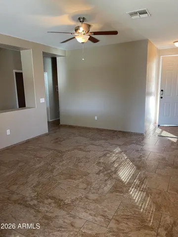 a view of a room with a ceiling fan and carpet
