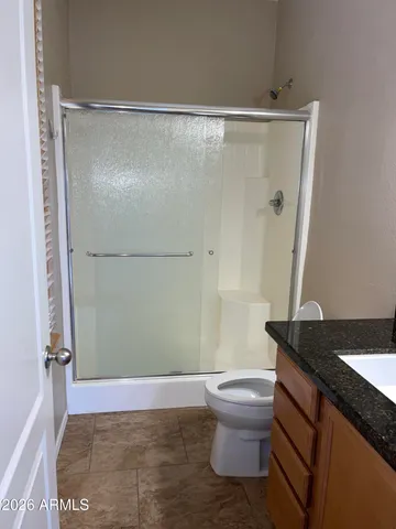 a bathroom with a granite countertop sink toilet and shower