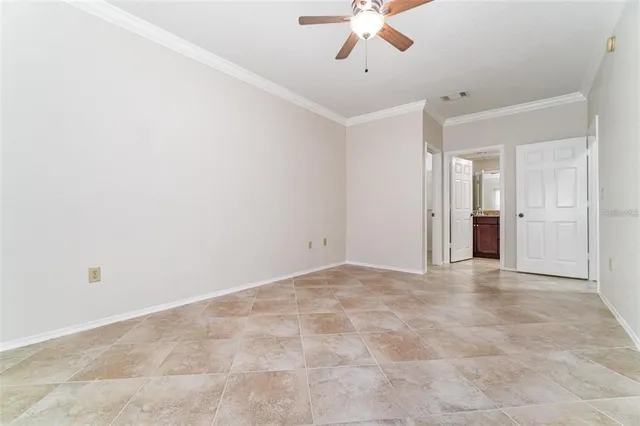 a view of an empty room with a chandelier fan