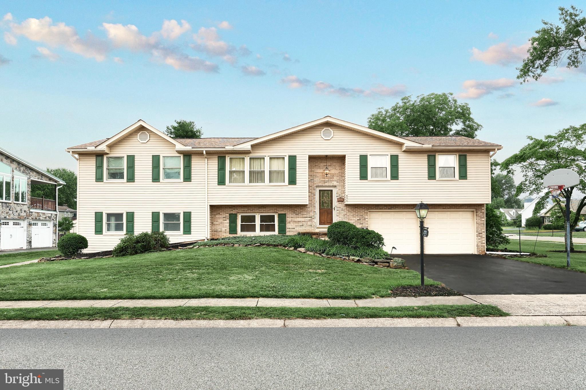 a front view of a house with a yard and trees