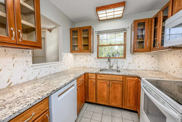 a kitchen with granite countertop a sink and a window