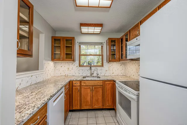 a kitchen with granite countertop a sink and a stove