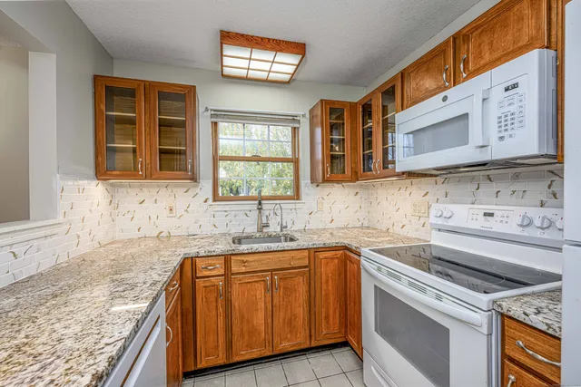 a kitchen with granite countertop a sink and a stove