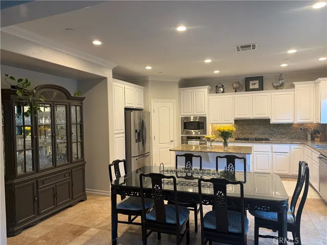 a kitchen with refrigerator and chairs