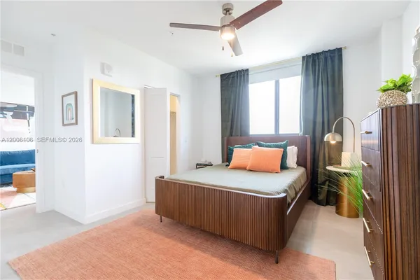 a bedroom with a bed table and a window
