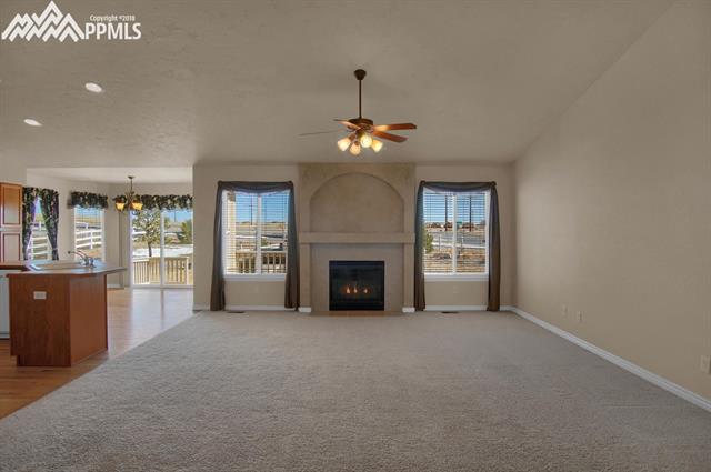 9162 Rockingham Drive Peyton, CO 80831 - Photo 9 of 35 Expansive great room with inviting gas fireplace flanked by two large windows for natural light.