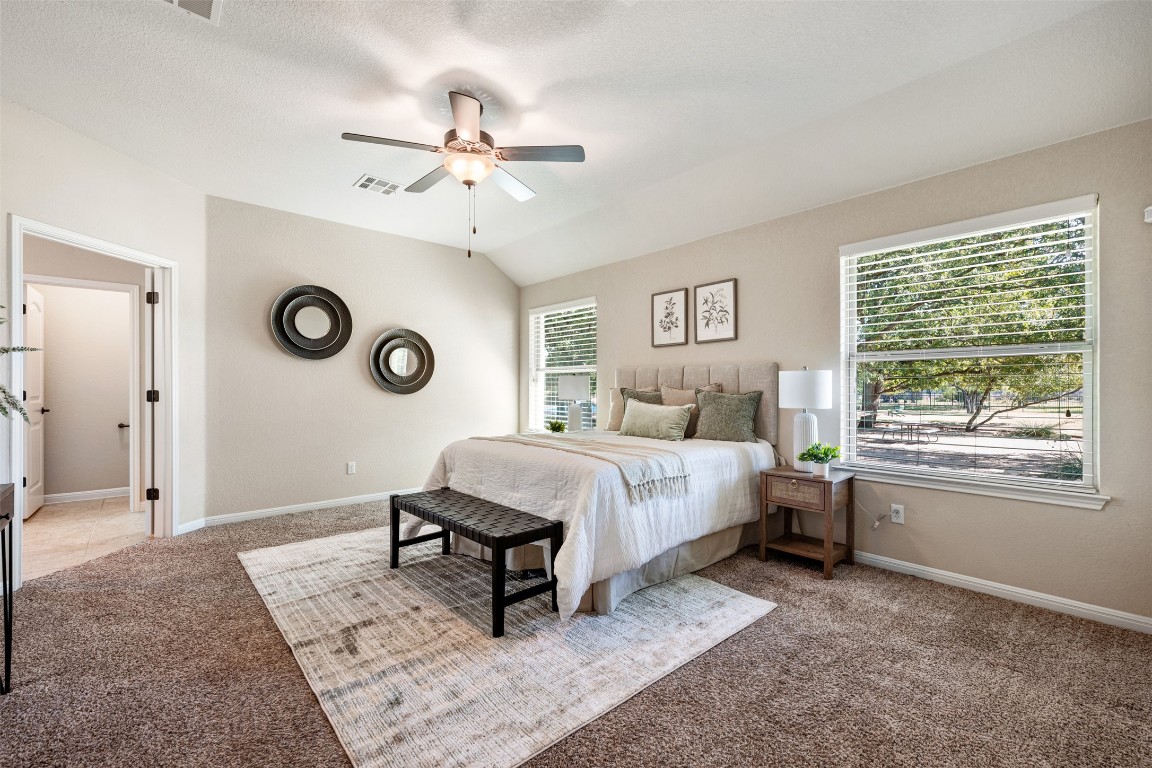 129 Camp Verde Drive Georgetown, TX 78633 - Photo 22 of 39 Carpeted bedroom with lofted ceiling, a ceiling fan, and a textured ceiling