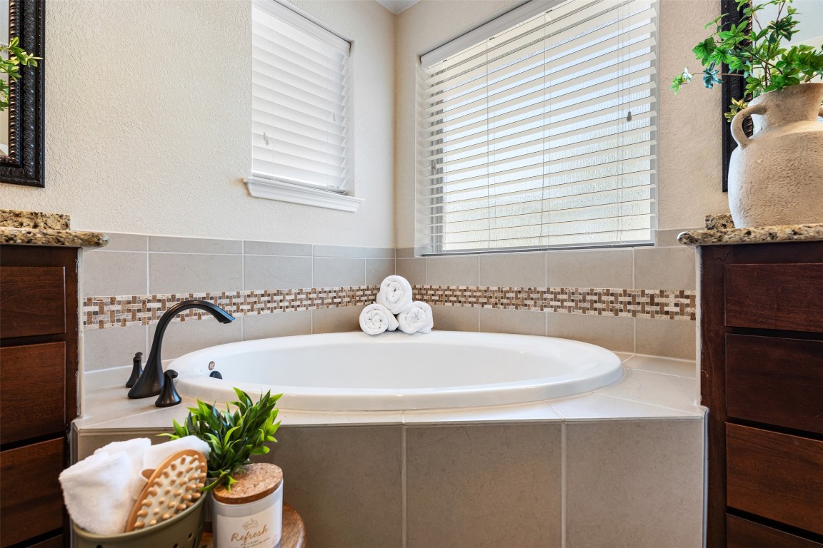 129 Camp Verde Drive Georgetown, TX 78633 - Photo 25 of 39 Main bedroom full bathroom featuring double vanity, a bath, and a textured wall and walking shower