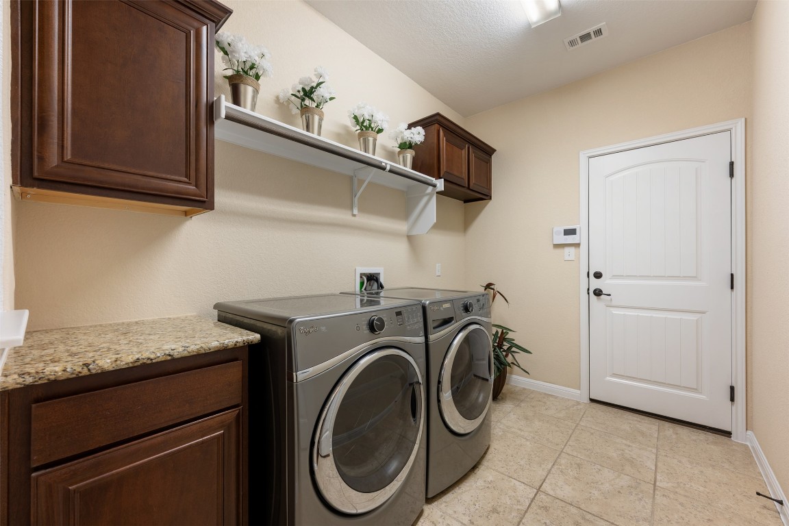 129 Camp Verde Drive Georgetown, TX 78633 - Photo 30 of 39 Laundry area with separate washer and dryer, light tile patterned floors, and cabinet space