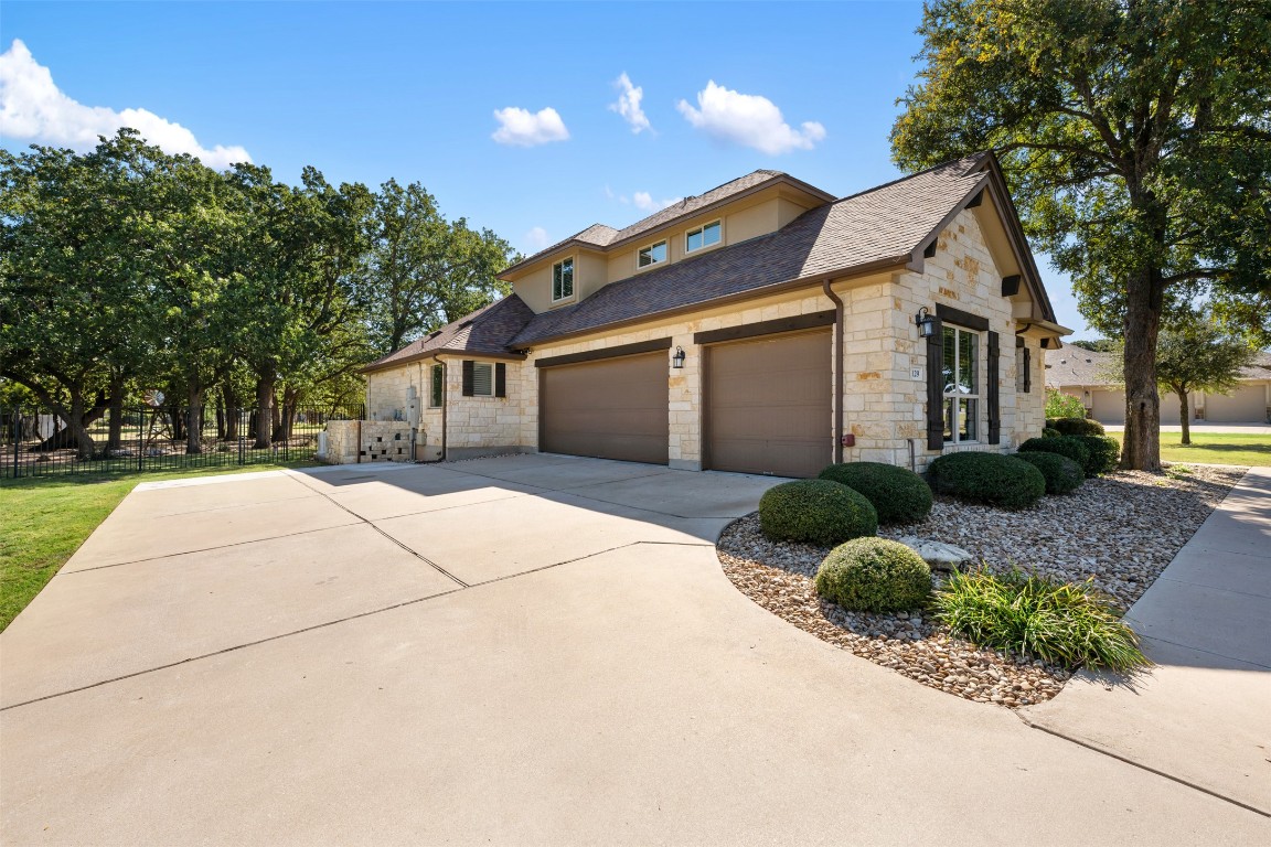 129 Camp Verde Drive Georgetown, TX 78633 - Photo 4 of 39 View of front of property with stone siding, an attached garage, concrete driveway, and roof with shingles