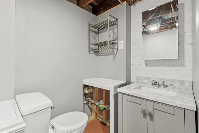 a bathroom with a sink vanity mirror and toilet