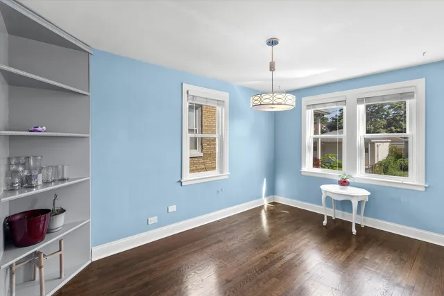 a dining room with wooden floor and a window