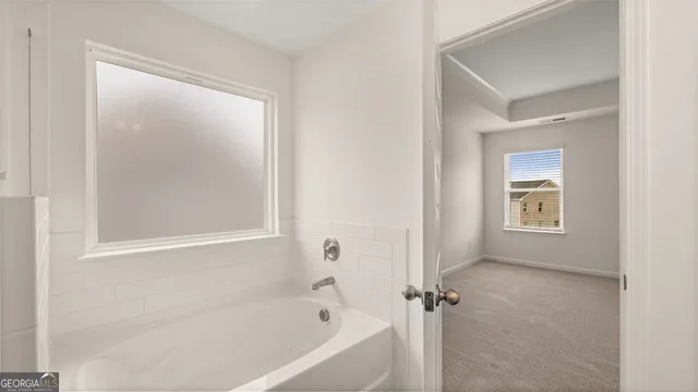 a white bath tub sitting next to a shower