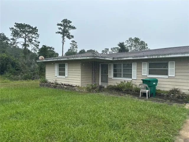 a view of a house with a yard and sitting area