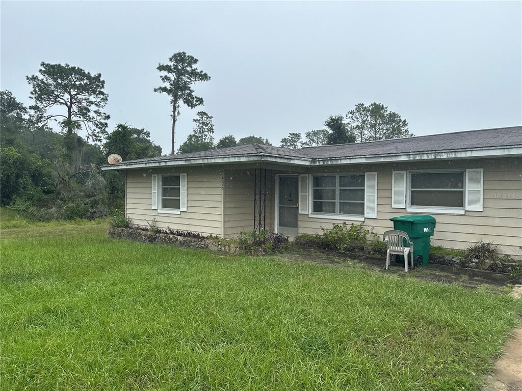 a view of a house with a yard and sitting area