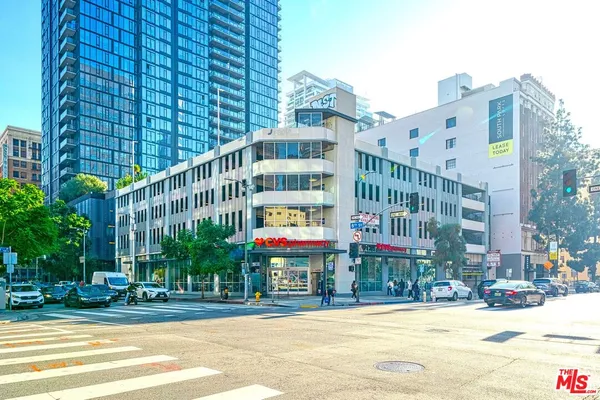 a front view of multi story residential apartment building with yard and traffic signal