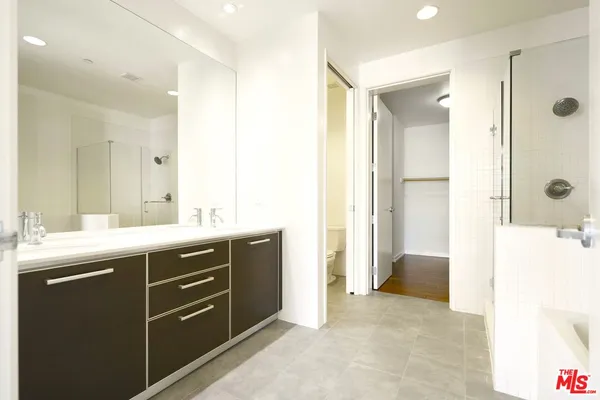 a spacious bathroom with a shower sink and mirror