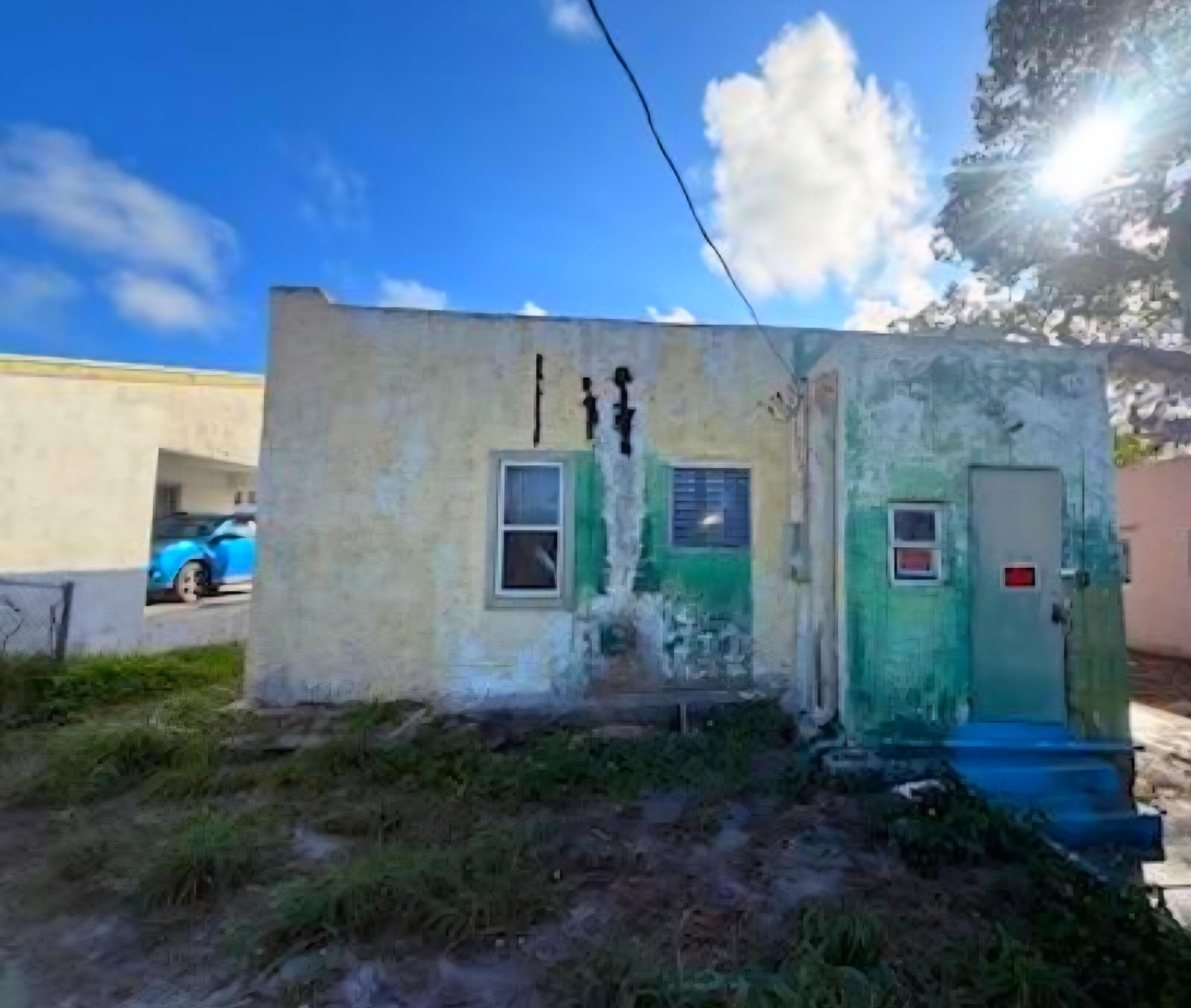 1150 West 25th Street Riviera Beach, FL 33404 - Photo 5 of 19 a view of a house with brick walls and a yard with plants
