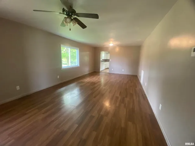 wooden floor in an empty room with a window