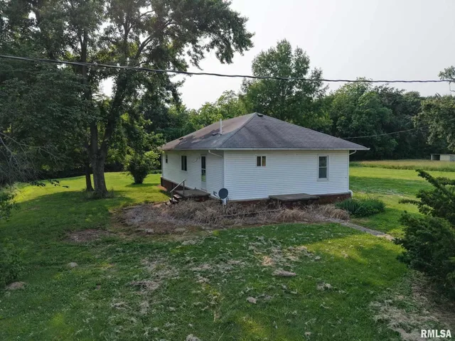 a aerial view of a house with a yard and trees