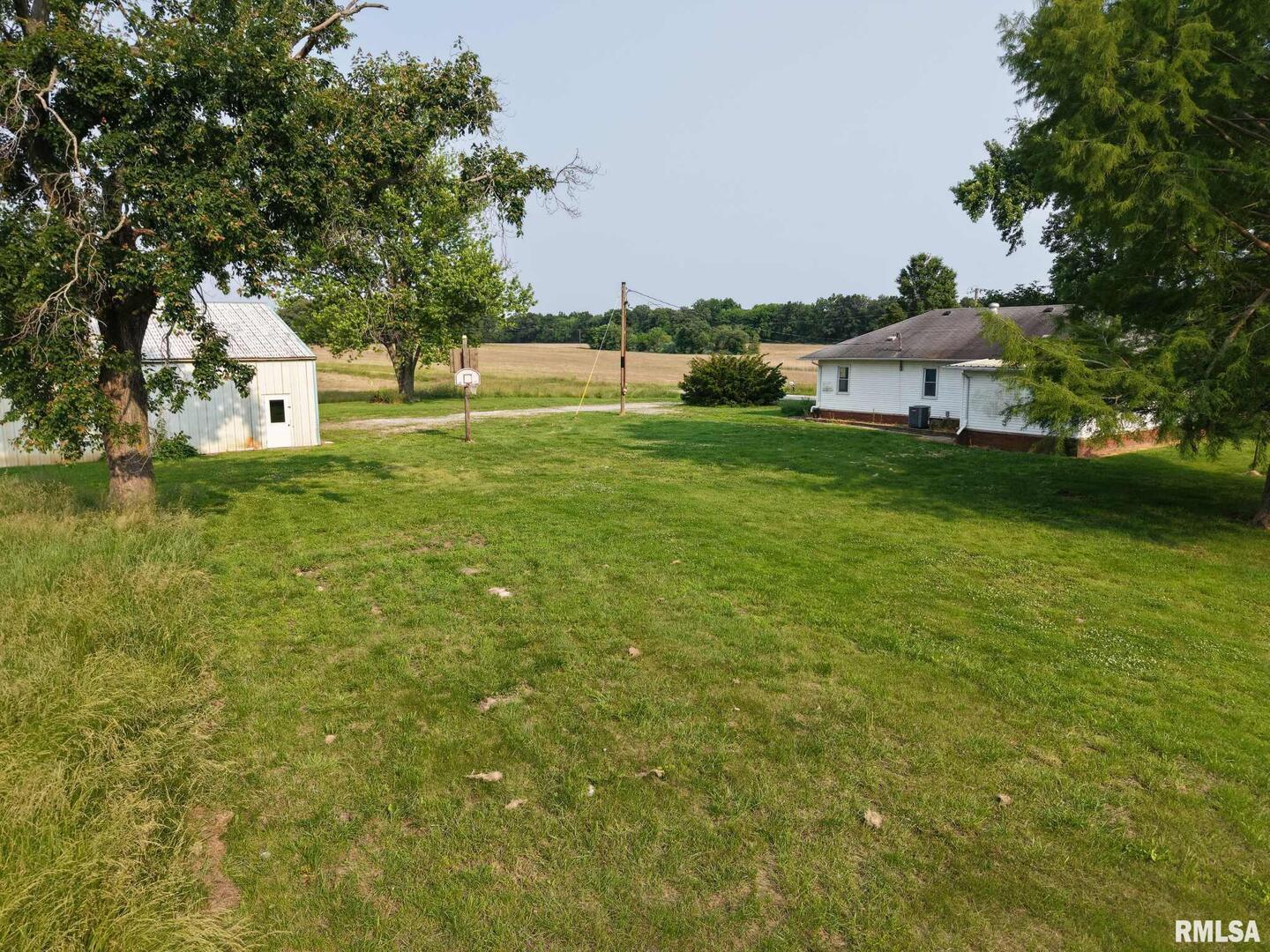 22545 Thompsonville Lake Road Thompsonville, IL 62890 - Photo 5 of 38 a view of a green field with house in the background