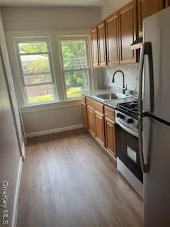 a kitchen with kitchen island granite countertop a stove wooden floor and a window