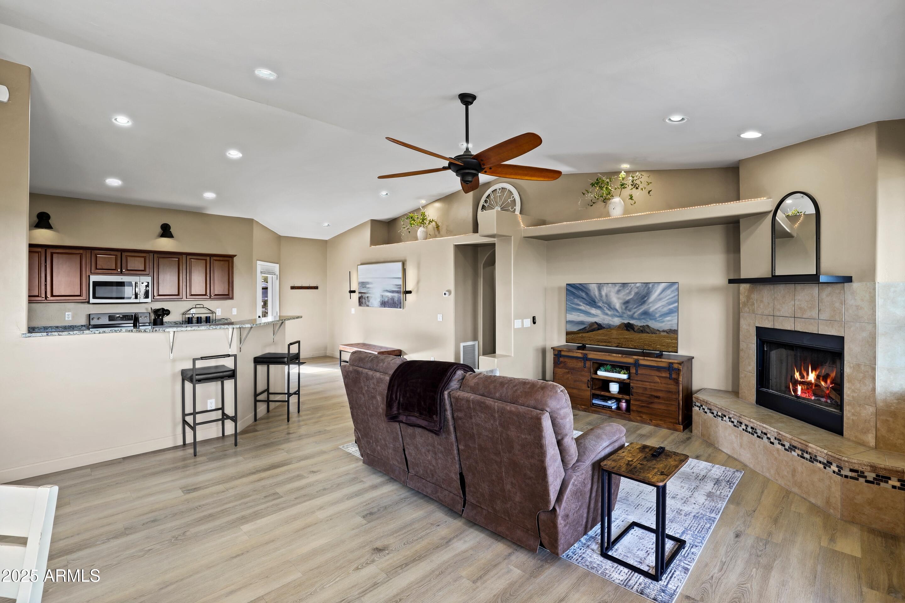 308 West Rim View Road Payson, AZ 85541 - Photo 11 of 57 a living room with furniture a fireplace and kitchen view