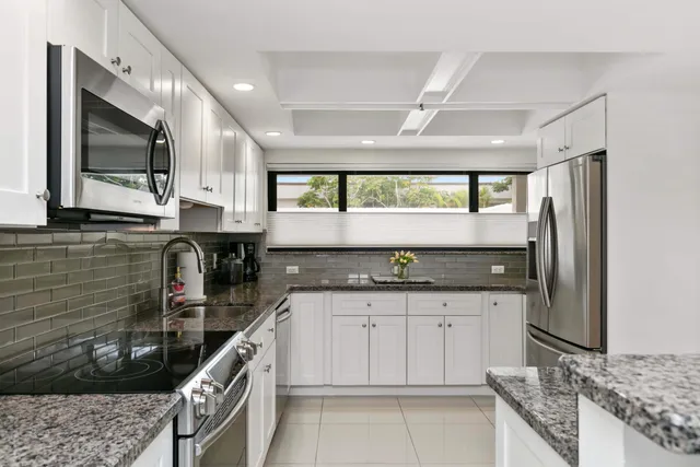 a kitchen with stainless steel appliances granite countertop a sink and a stove