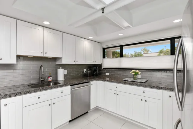 a kitchen with granite countertop white cabinets white appliances and a granite counter tops