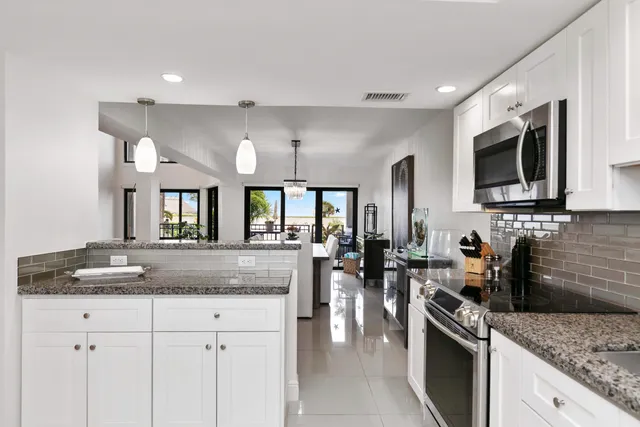 a kitchen with stainless steel appliances granite countertop a sink stove and microwave