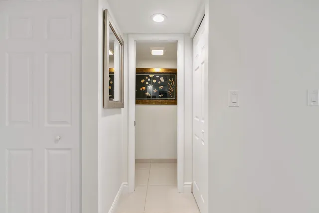 a view of a hallway with wooden floor and closet