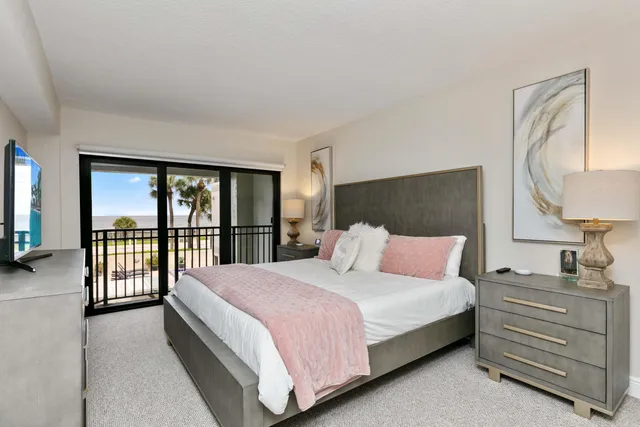 a bedroom with a bed a lamp and a large window