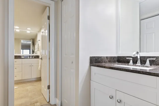 a bathroom with a granite countertop sink mirror and vanity