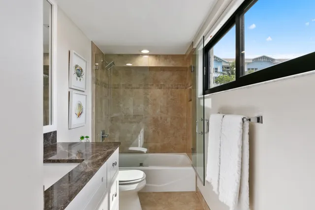 a bathroom with a granite countertop sink toilet and shower