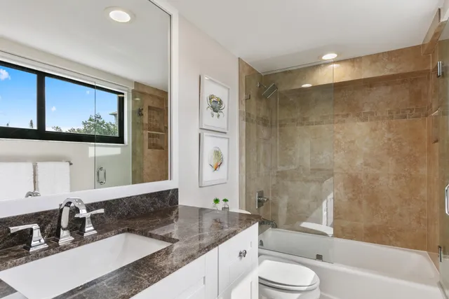 a bathroom with a granite countertop sink toilet and shower