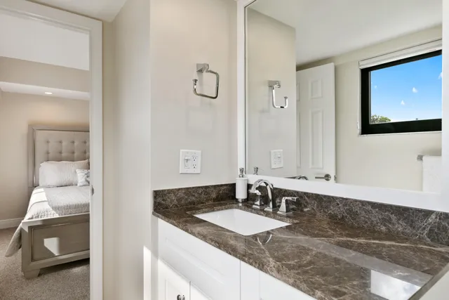 a bathroom with a granite countertop sink and a mirror