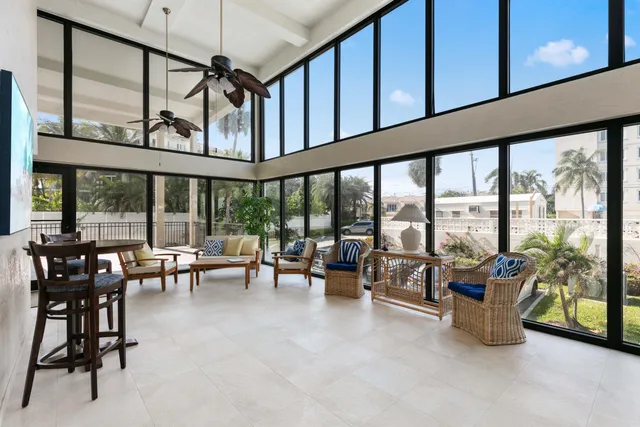 a living room with furniture and floor to ceiling windows
