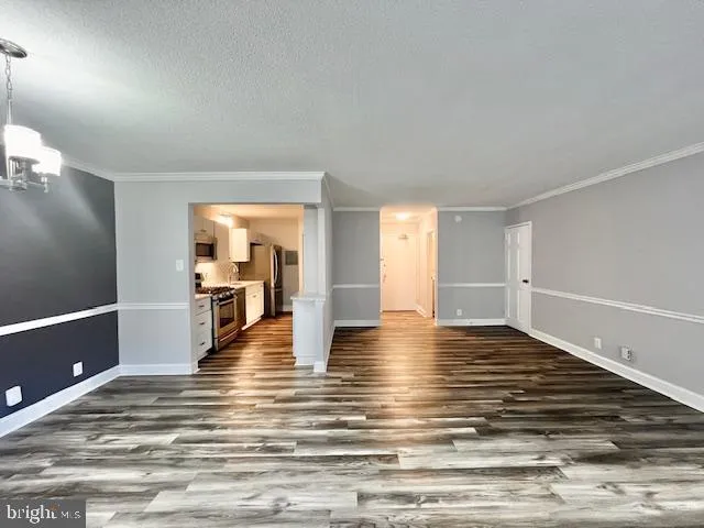 a view of a living room and kitchen with furniture and wooden floor
