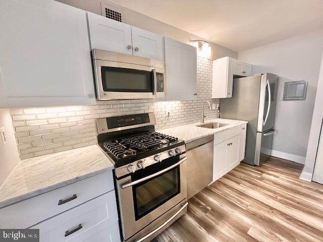 4515 Willard Avenue, Unit 1014S Chevy Chase, MD 20815 - Photo 5 of 35 a kitchen with white cabinets and stainless steel appliances