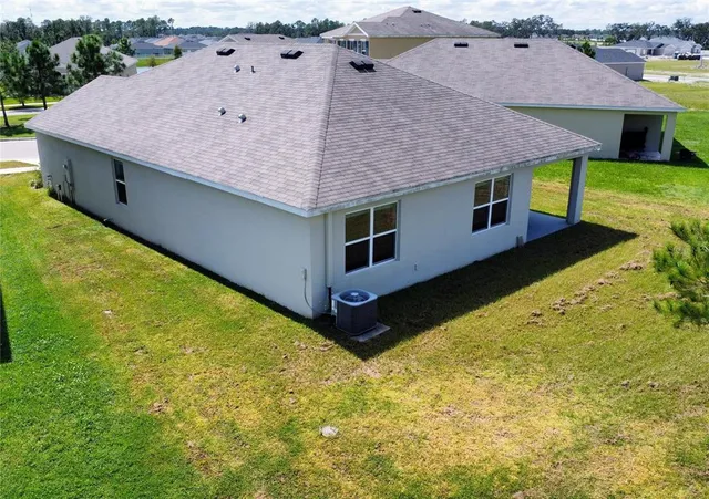 a aerial view of a house with a yard and potted plants
