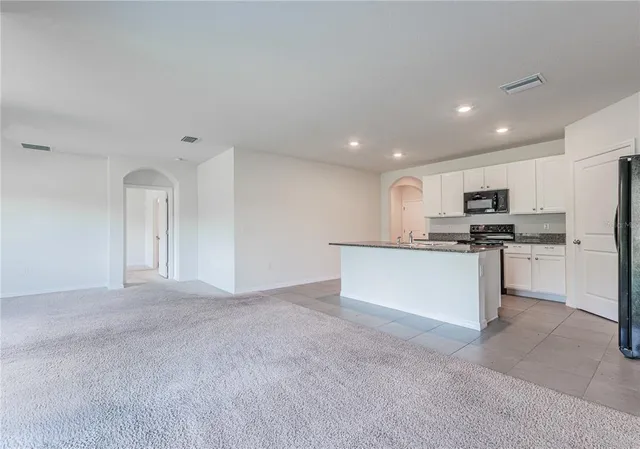 a view of a kitchen with a sink and chandelier fan