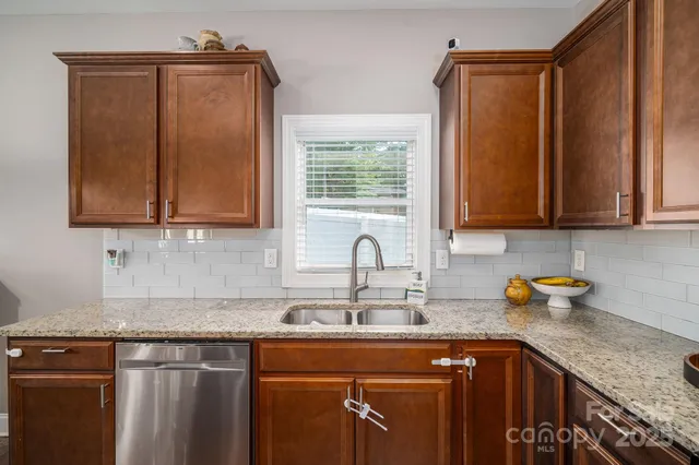 a kitchen with stainless steel appliances granite countertop a stove a microwave and wooden cabinets