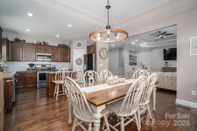 a kitchen with granite countertop a stove top oven a sink a dining table and chairs