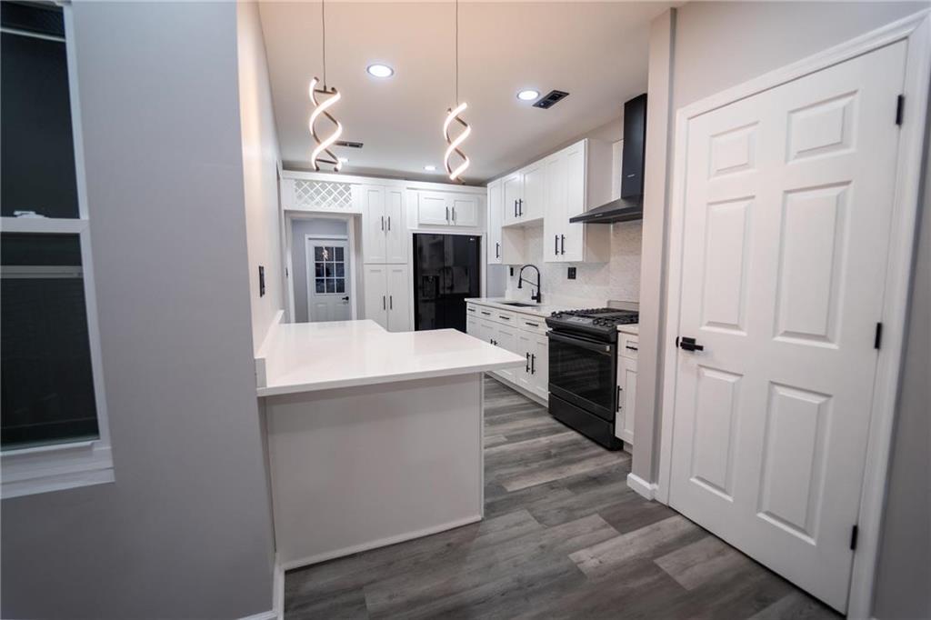 a large kitchen with stainless steel appliances kitchen island a large counter top and a sink