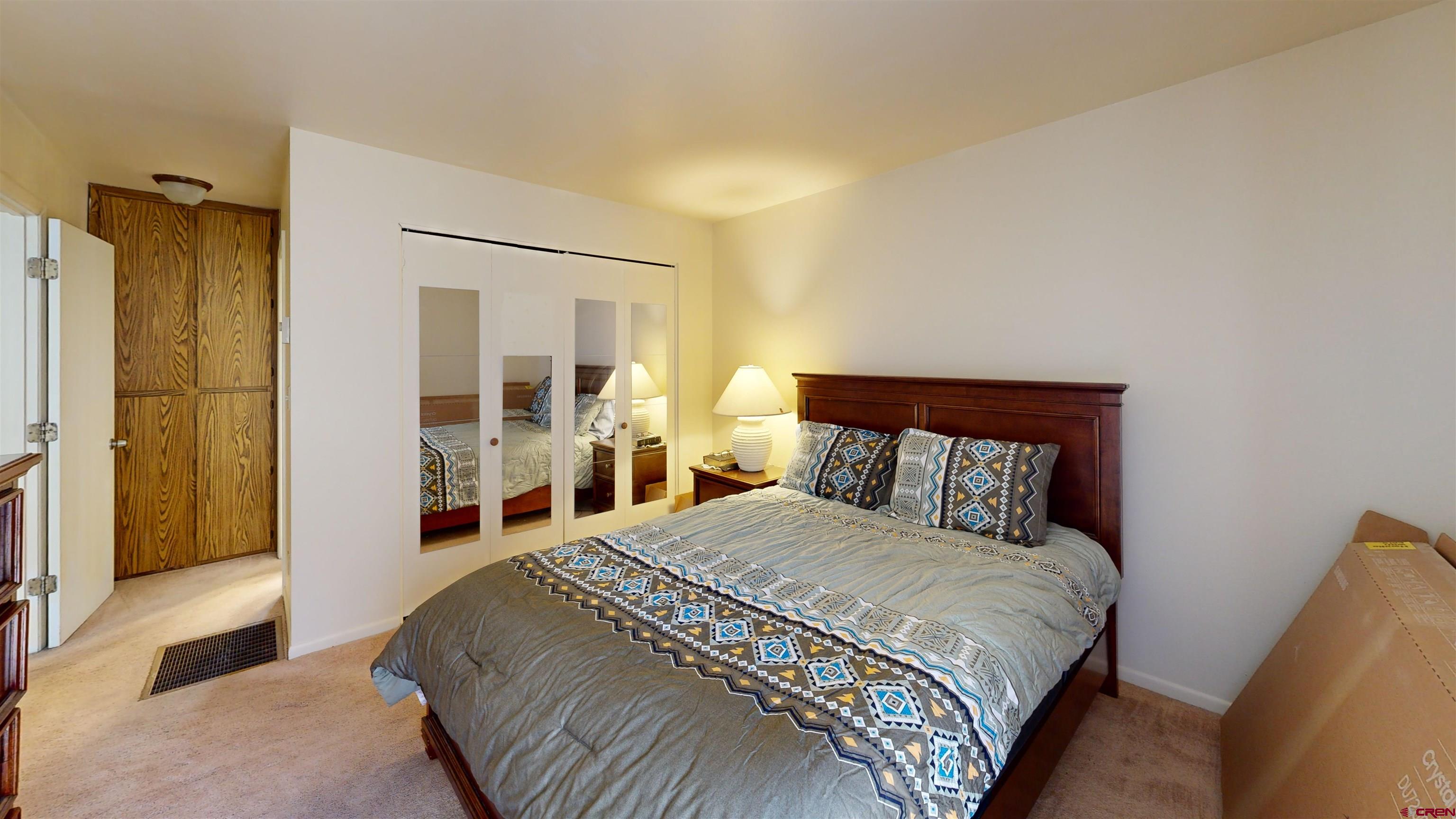 1200 Florida Road, Unit 33 Durango, CO 81301 - Photo 10 of 22 a bedroom with a bed and a large mirror with a wooden floor